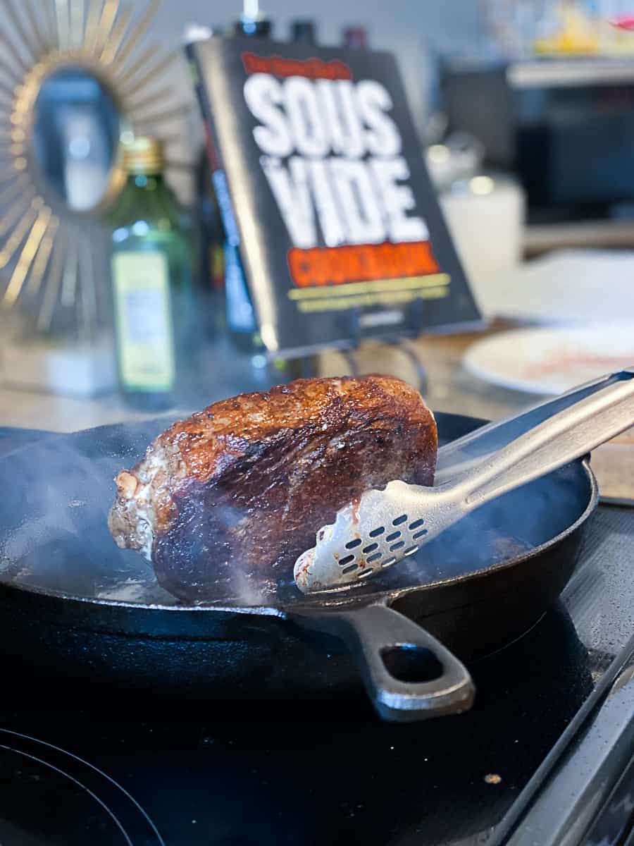 using tongs to sear mayo steak with the home chef's sous vide cookbook