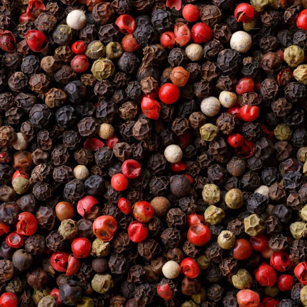 closeup of red, black, green and white peppercorns