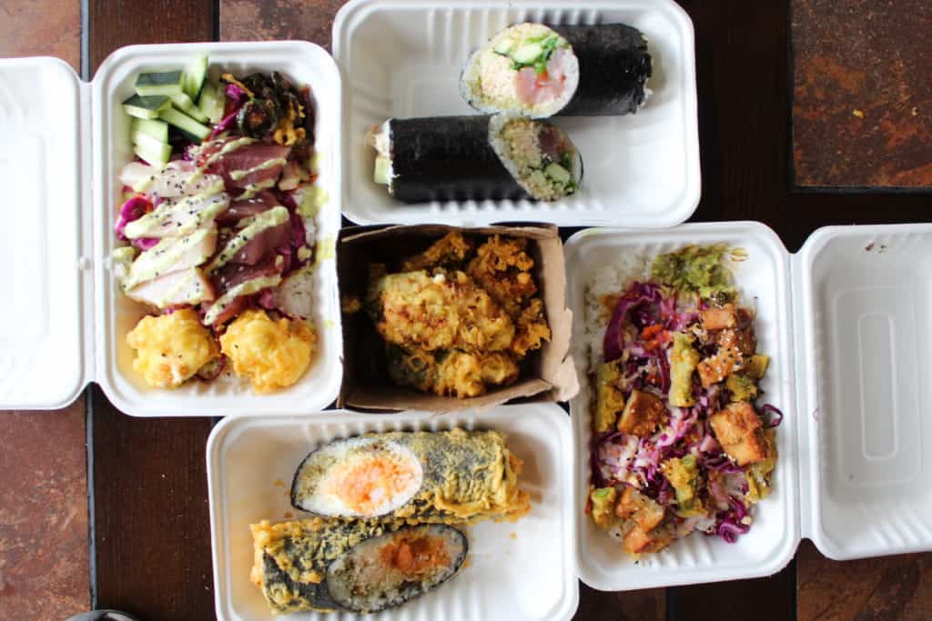 sushi burrito, fried sushi burrito, poke bowl, vegan bowl, and fried appetizer, all in take out containers