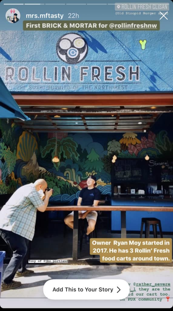 photographer taking man's photograph while he's sitting under the rollin fresh storefront