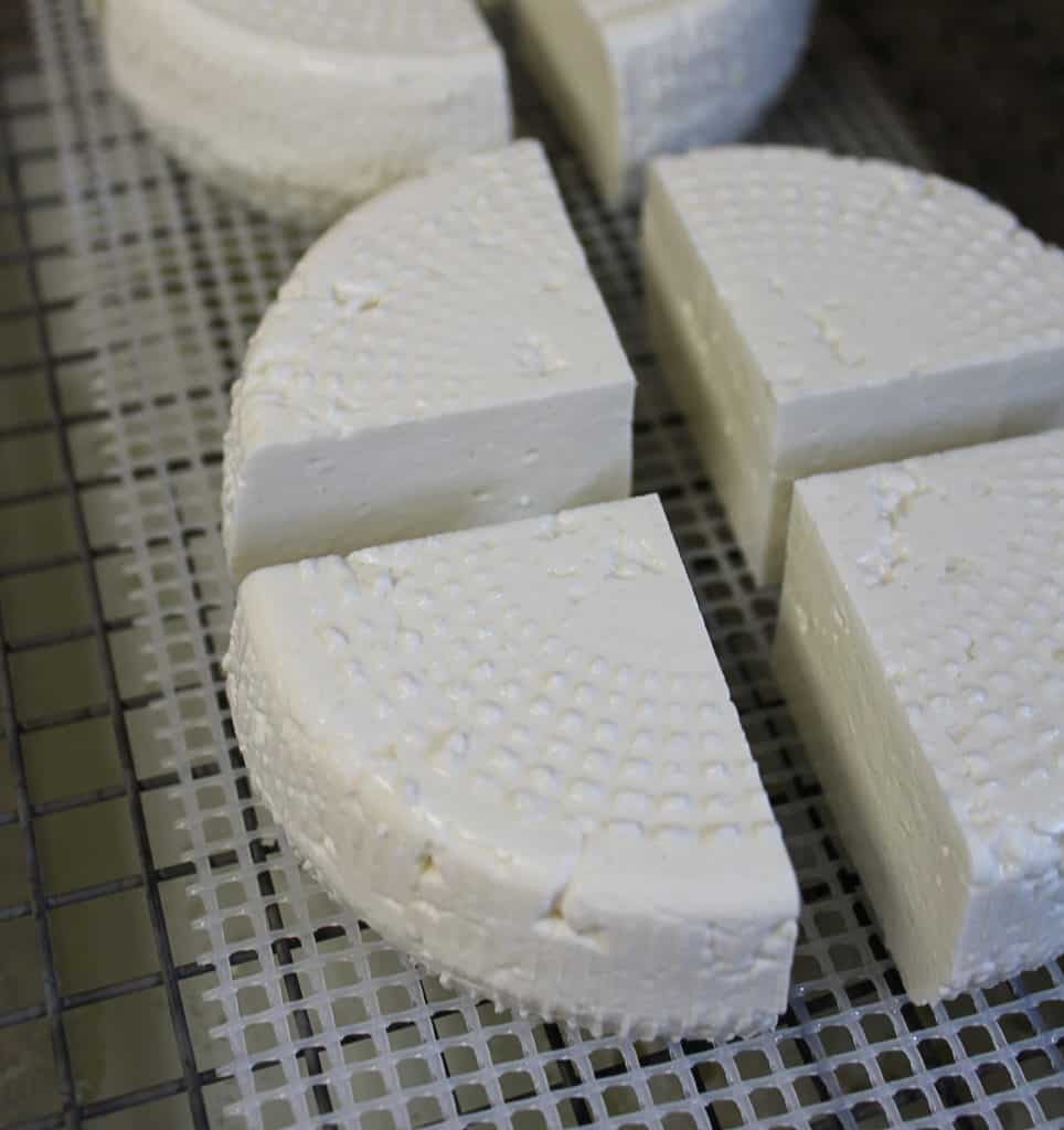 a quartered wheel of feta cheese on a rack