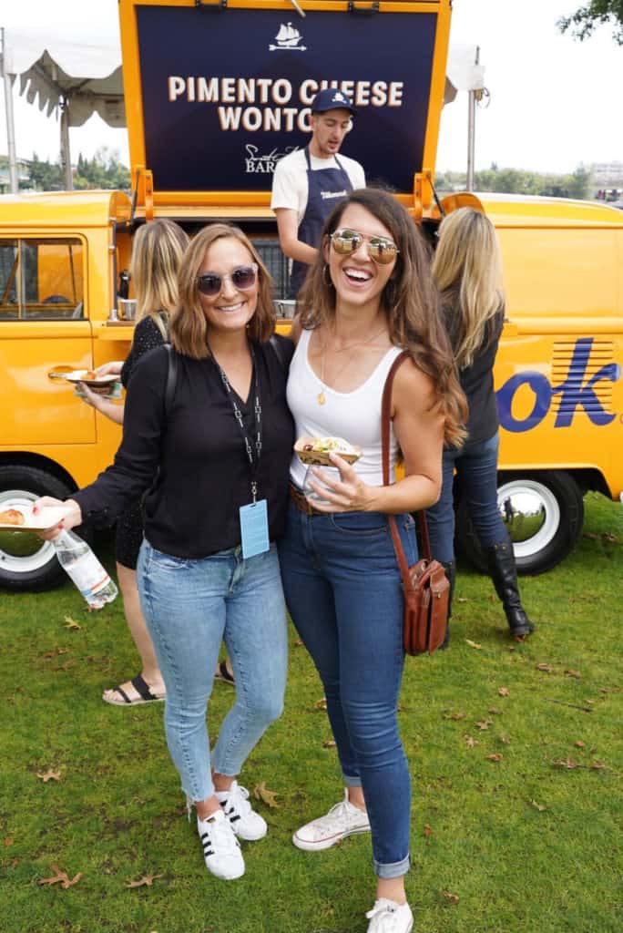 two women smiling holding plates in front of a tillamook food truck