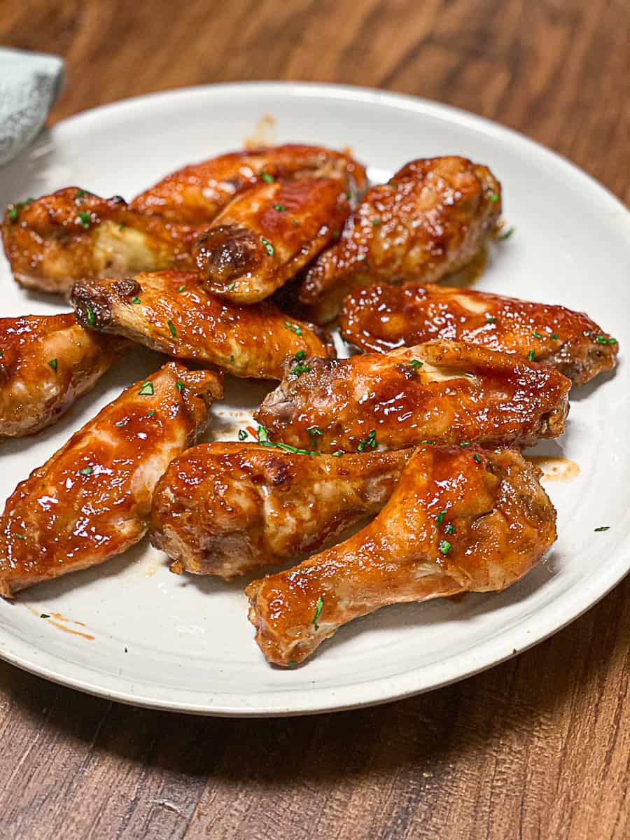 BBQ chicken wings on white plate.
