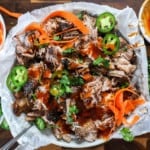 Top shot of barbecue pork shredded with jalapenos and barbecue sauce.