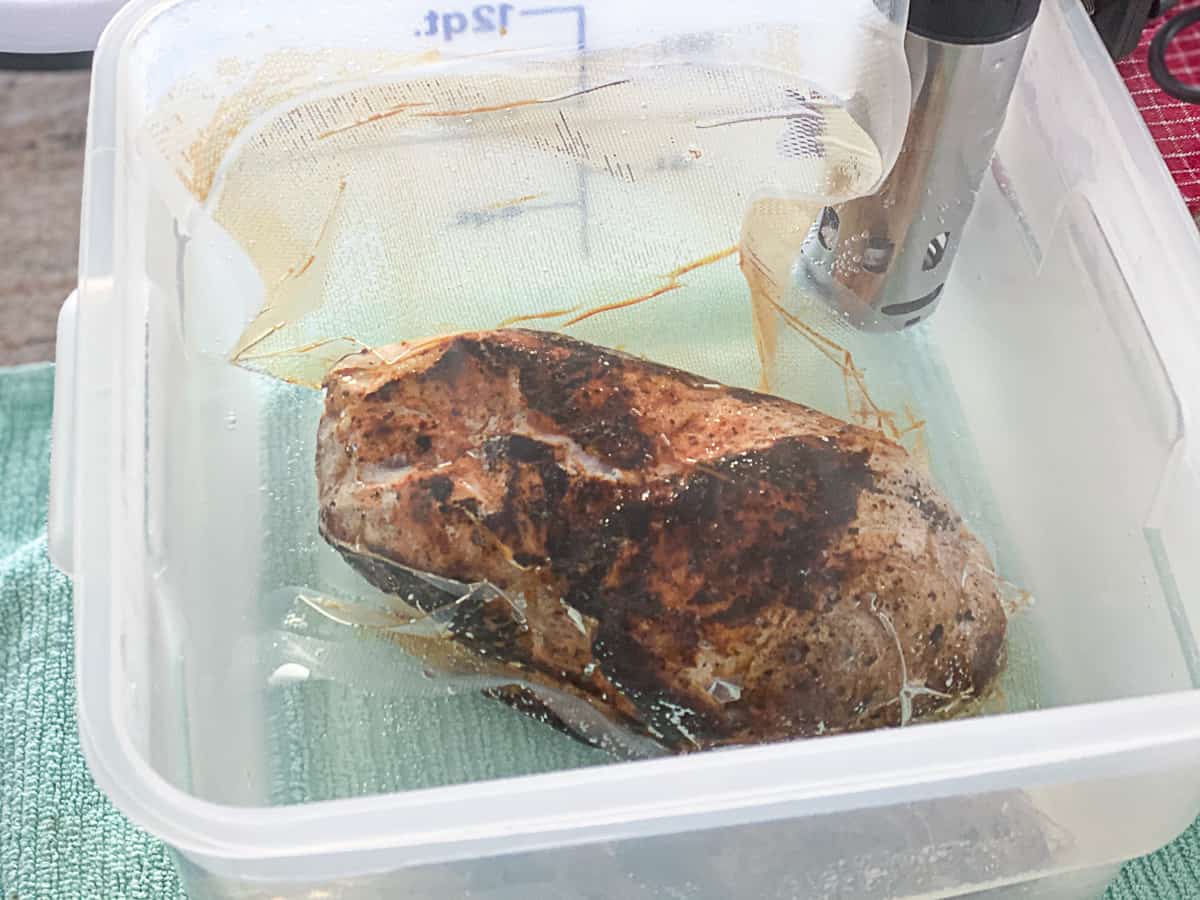 Pork in vacuum sealed bag in sous vide bath.