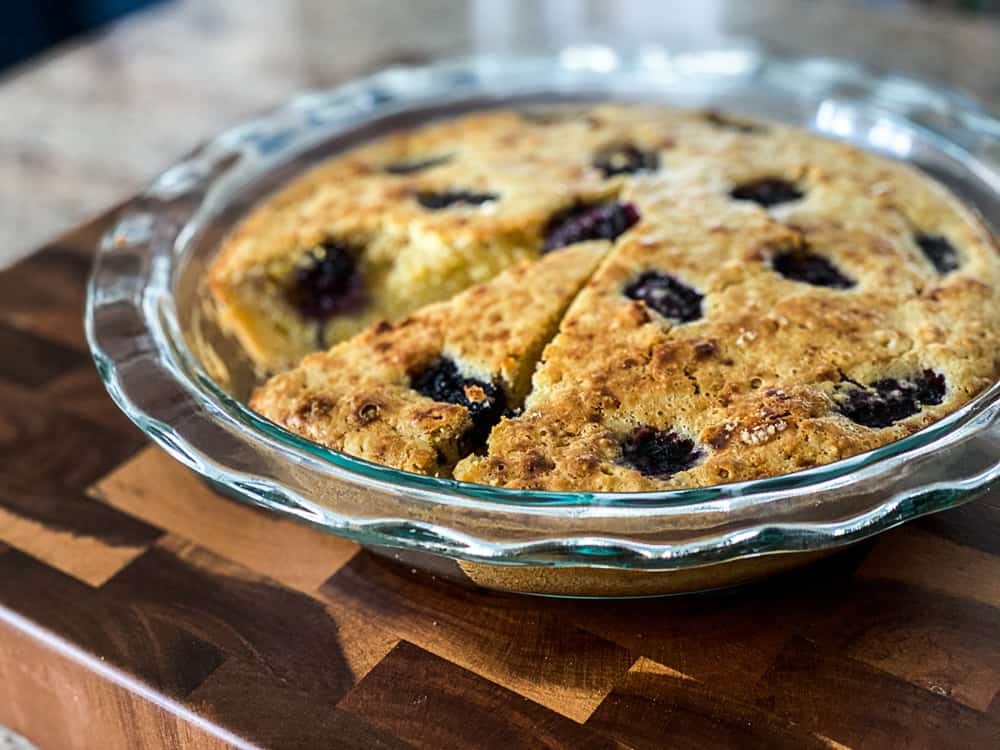 Side shot of baked olive oil cake with berries.