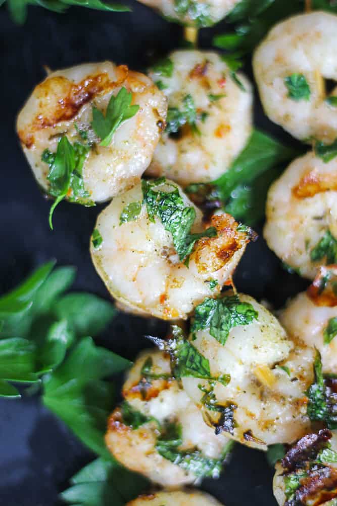 Top shot of shrimp sous vide cooked on a stick with fresh herbs.