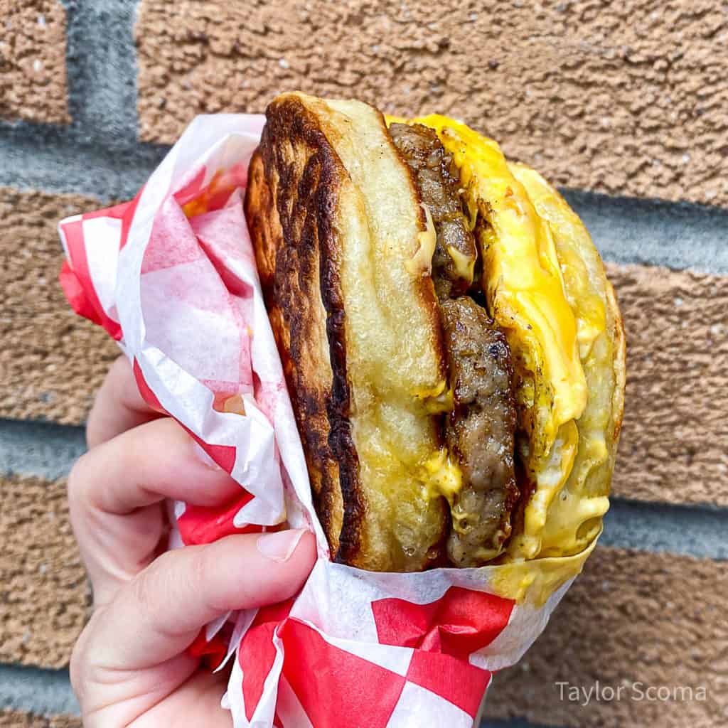 close up of a hand holding a breakfast sandwich