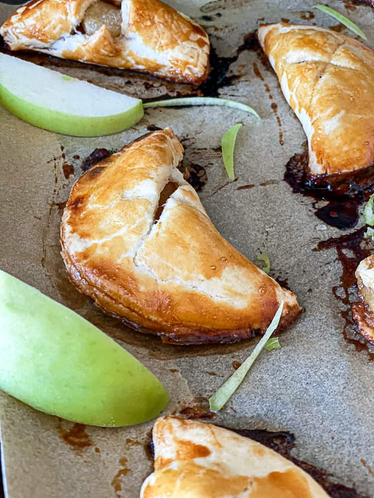 Side shot of mini apple pies and apple slices.