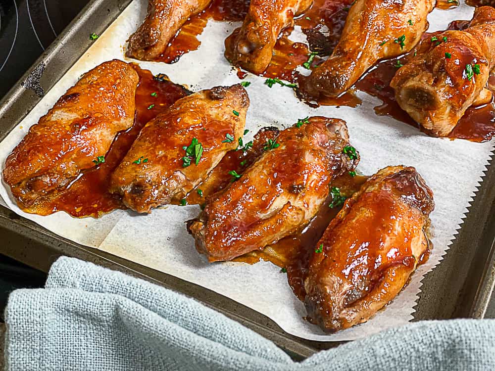 Side shot of sous vide chicken wings with sauce.