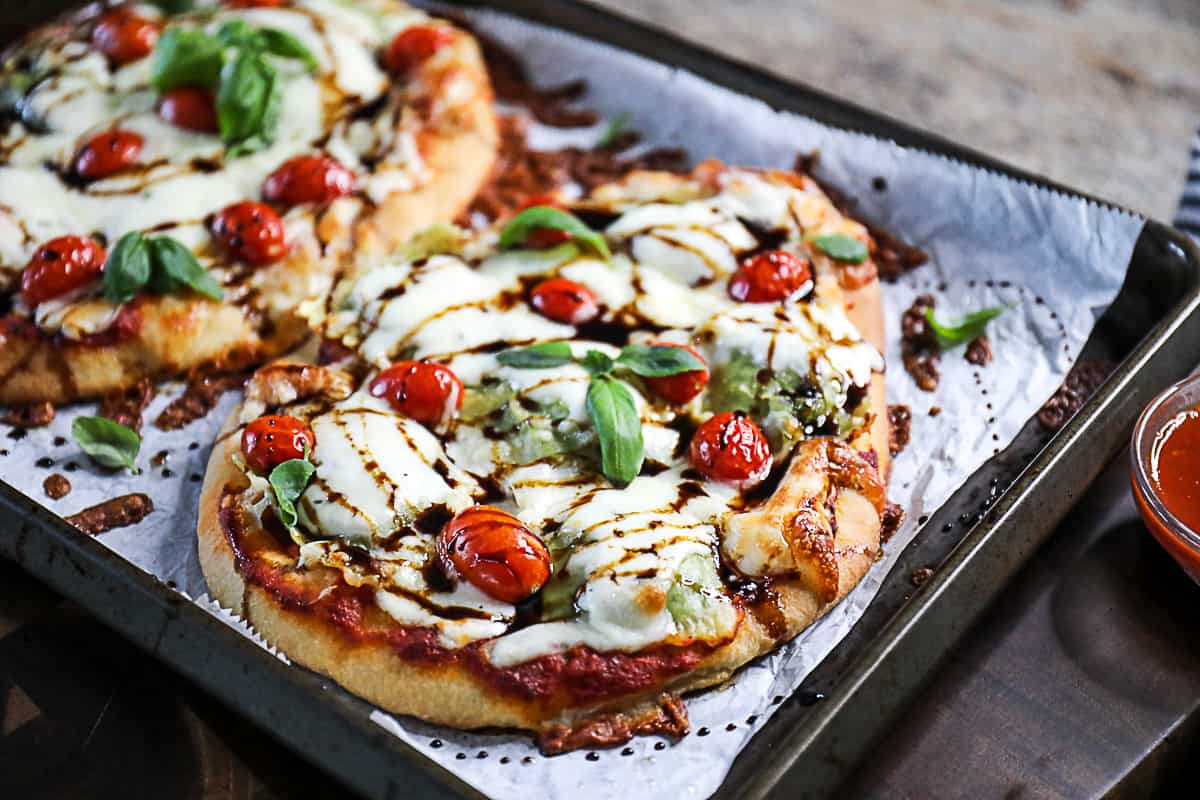 Side shot of pasta pizza on a pan.