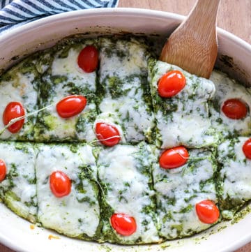 Top shot of melted mozzarella cheese on keto friendly spinach pesto lasagna with tomatoes.