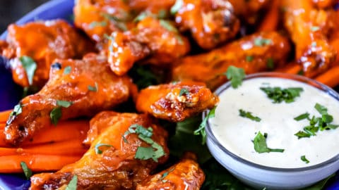 Side shot of Air Fryer Chicken Wings served on a party plate with blue cheese dressing.