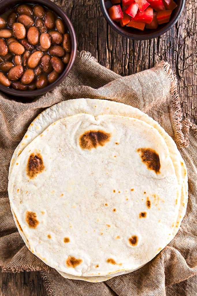 Top down shot of flour tortillas on a table.