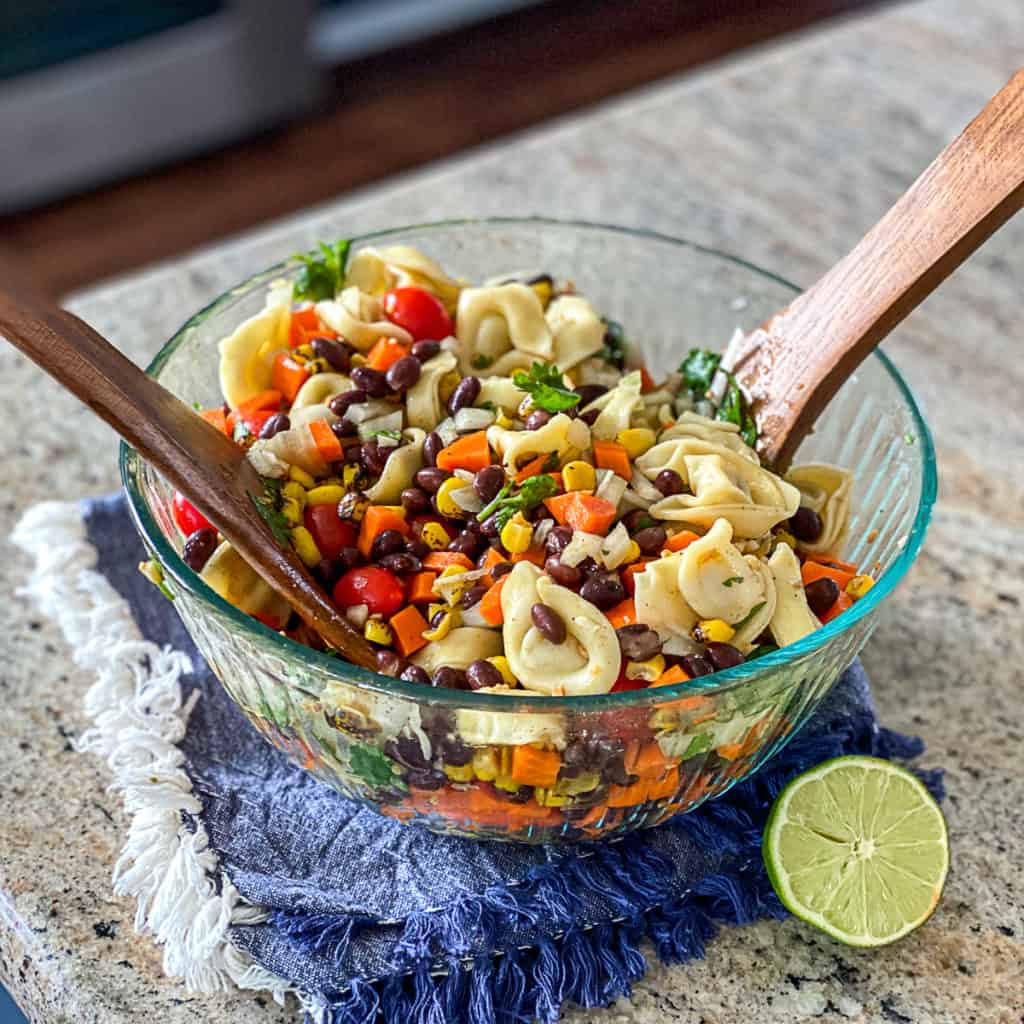 Side shot of bowl of tortellini pasta salad with black beans.