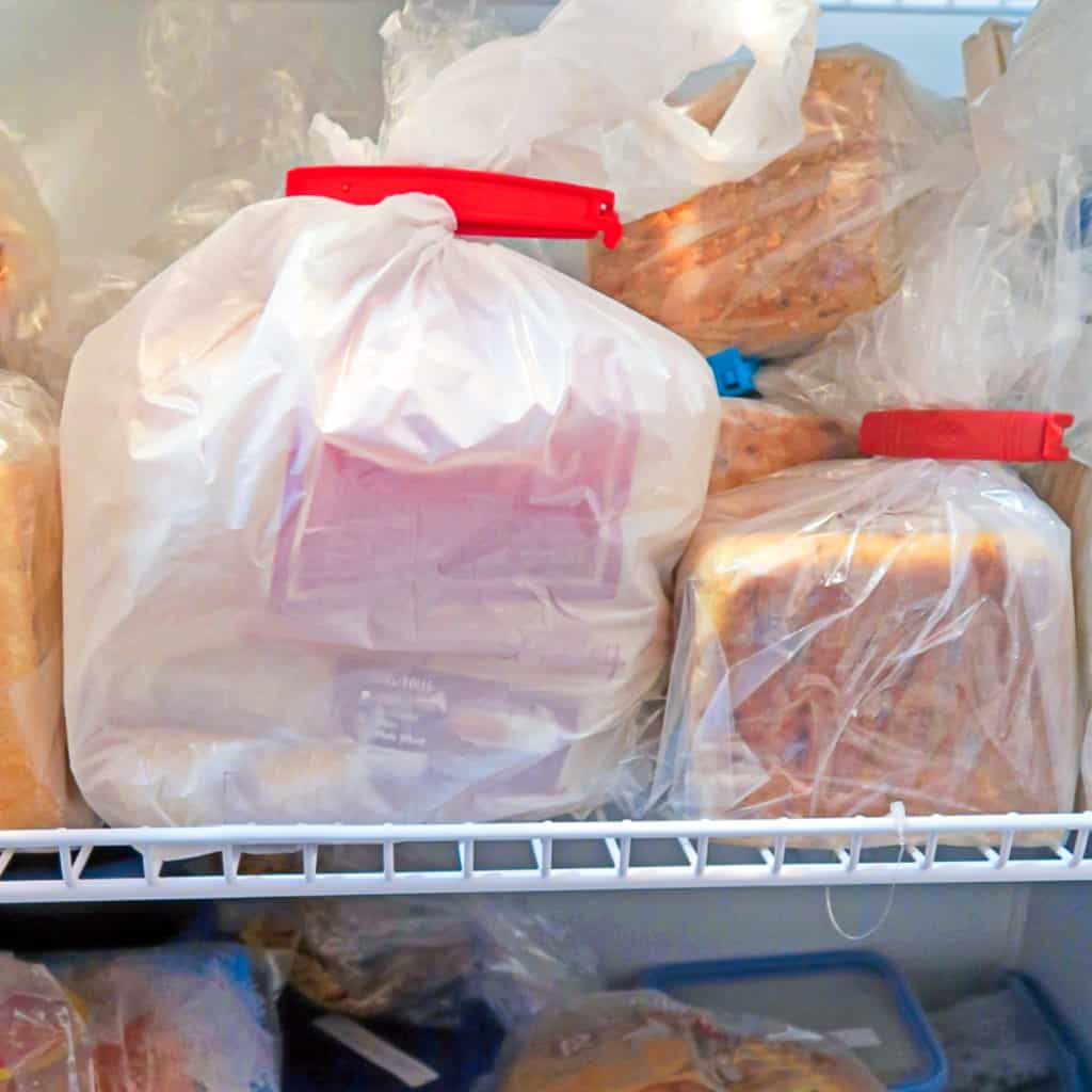 Side shot of bags of frozen bread in freezer.