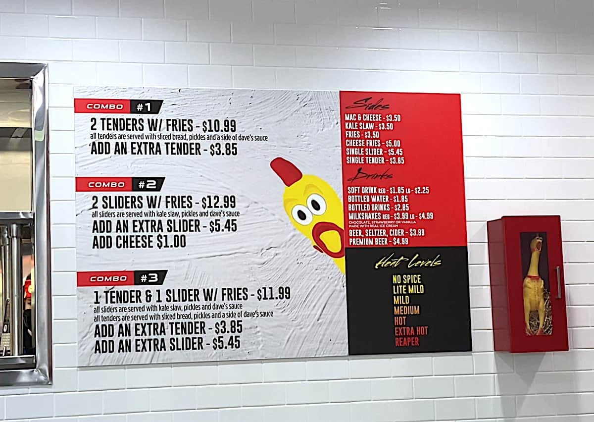 Dave's Hot Chicken Menu With Prices hanging on the wall of the restaurant.