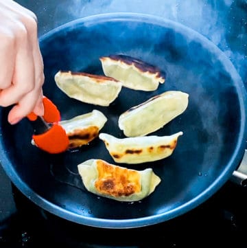 Top down shot demonstrating how to cook Trader Joe's Vegetable Gyoza in a pan.