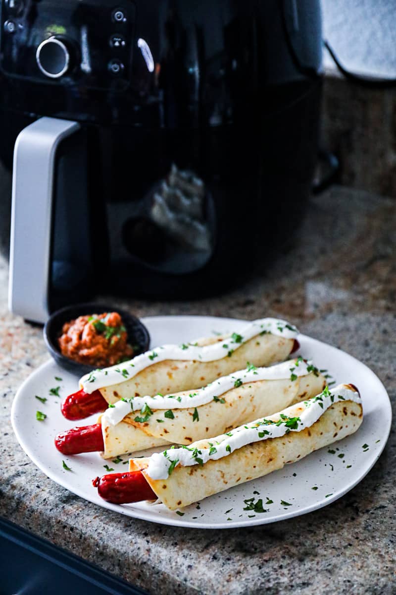 Air fryer Hot Dog Taquitos with sour cream and salsa.