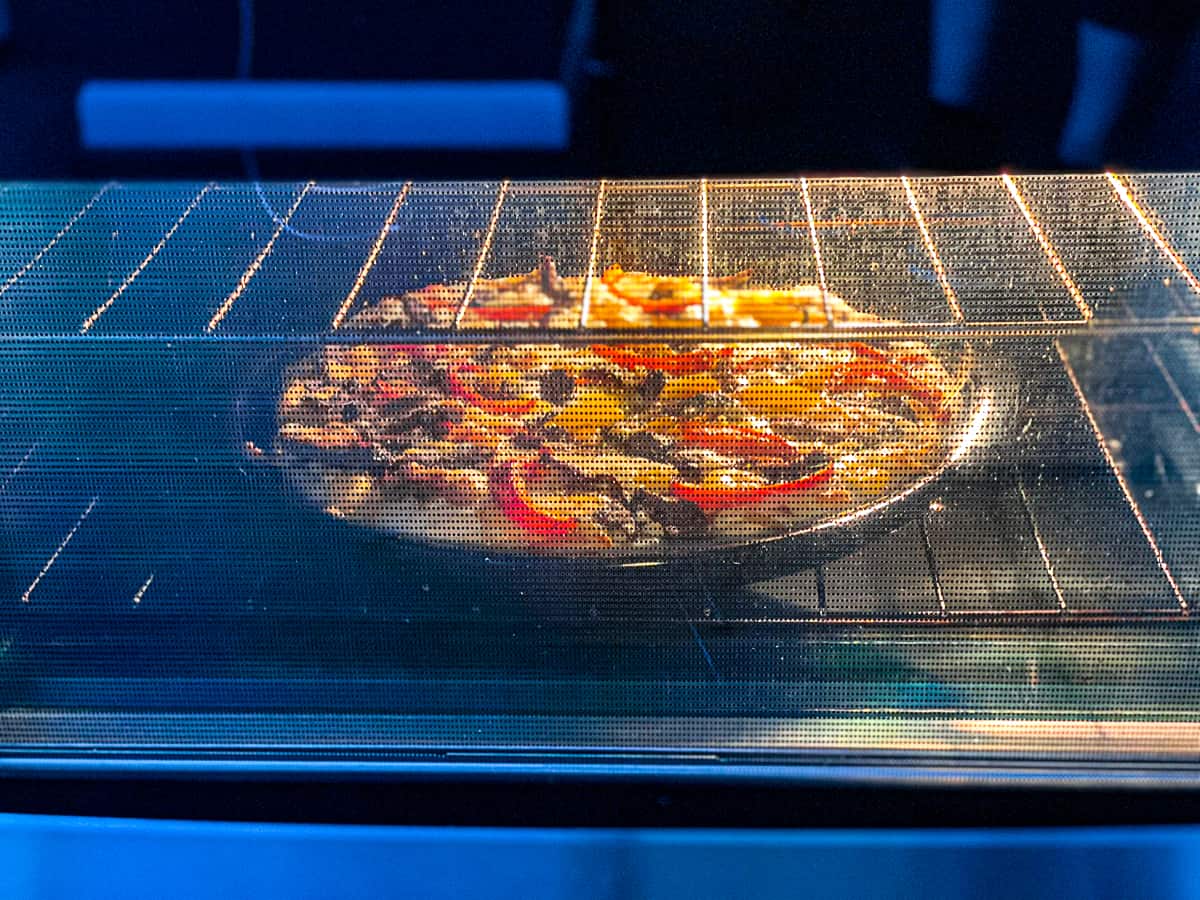 Side shot of convection oven cooking pizza.