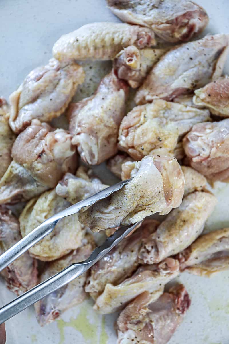 Raw chicken wings with dry rub seasoning.