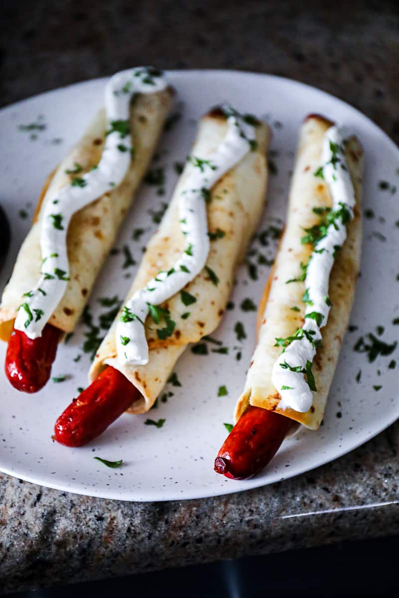 Baked Hot Dogs wrapped in flour tortillas.