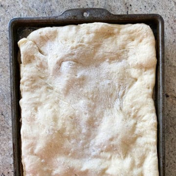 Top down shot of lightly Par Baked Pizza Dough using a sheet tray.
