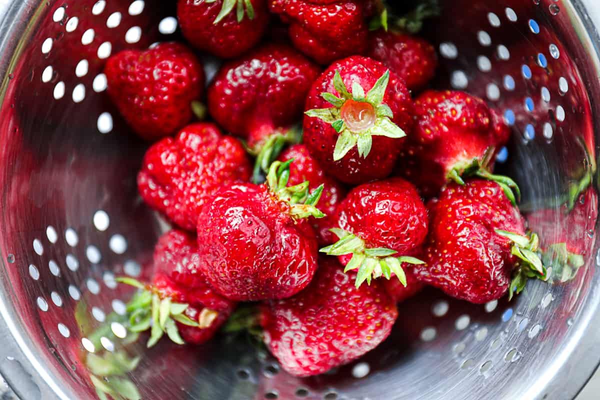 Top down shot of fresh strawberries in a colander.