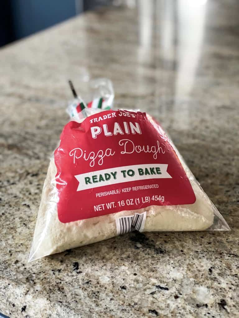 Side shot of Trader joe's Pizza Dough in a bag premade on counter.