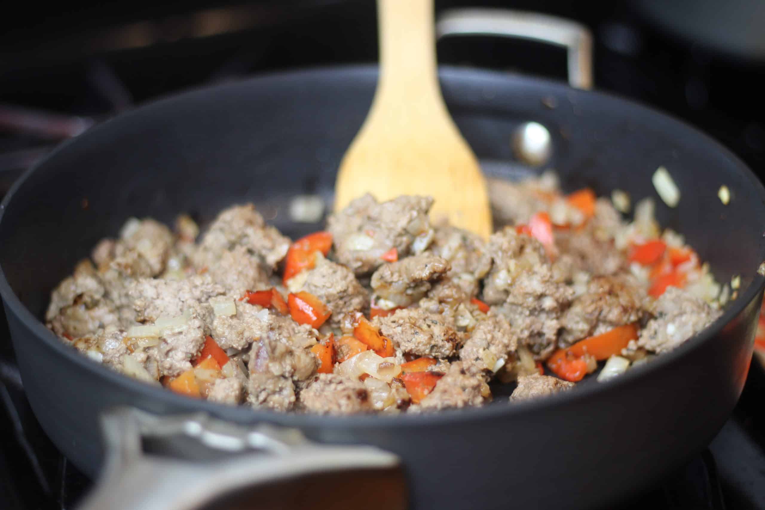 Cooking ground beef in a pan for pizza