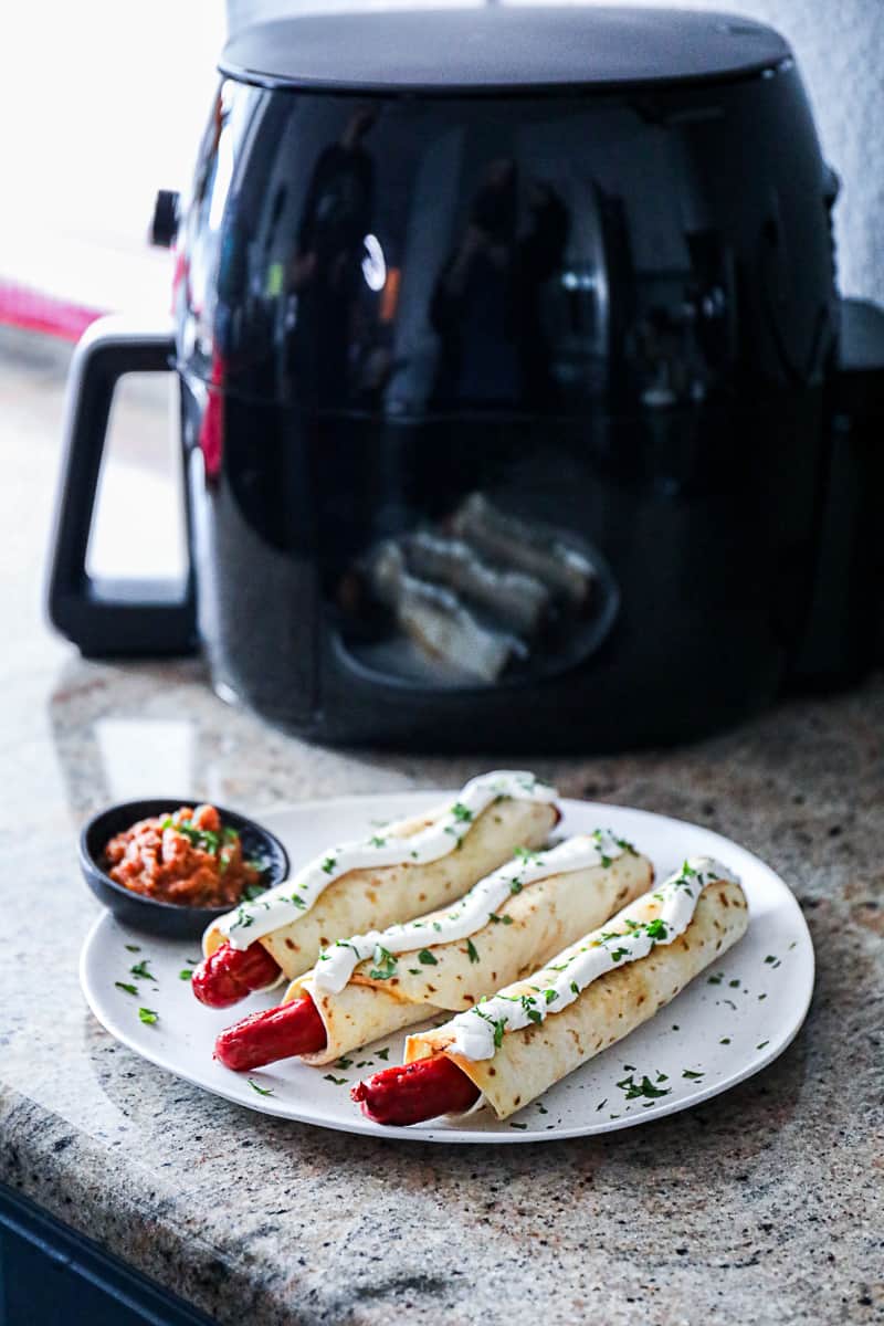 Frozen foods in air fryer example with hot dogs.