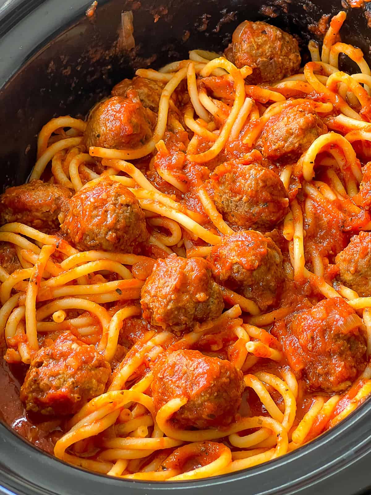 Slow Cooker Spaghetti and Meatballs Plate of spaghetti topped with slow-cooked meatballs and tomato sauce ready to serve