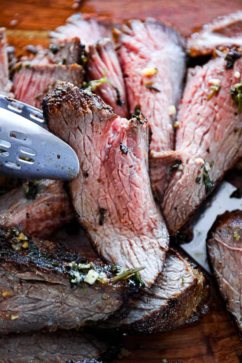 Thinly cut tri tip steak against the grain