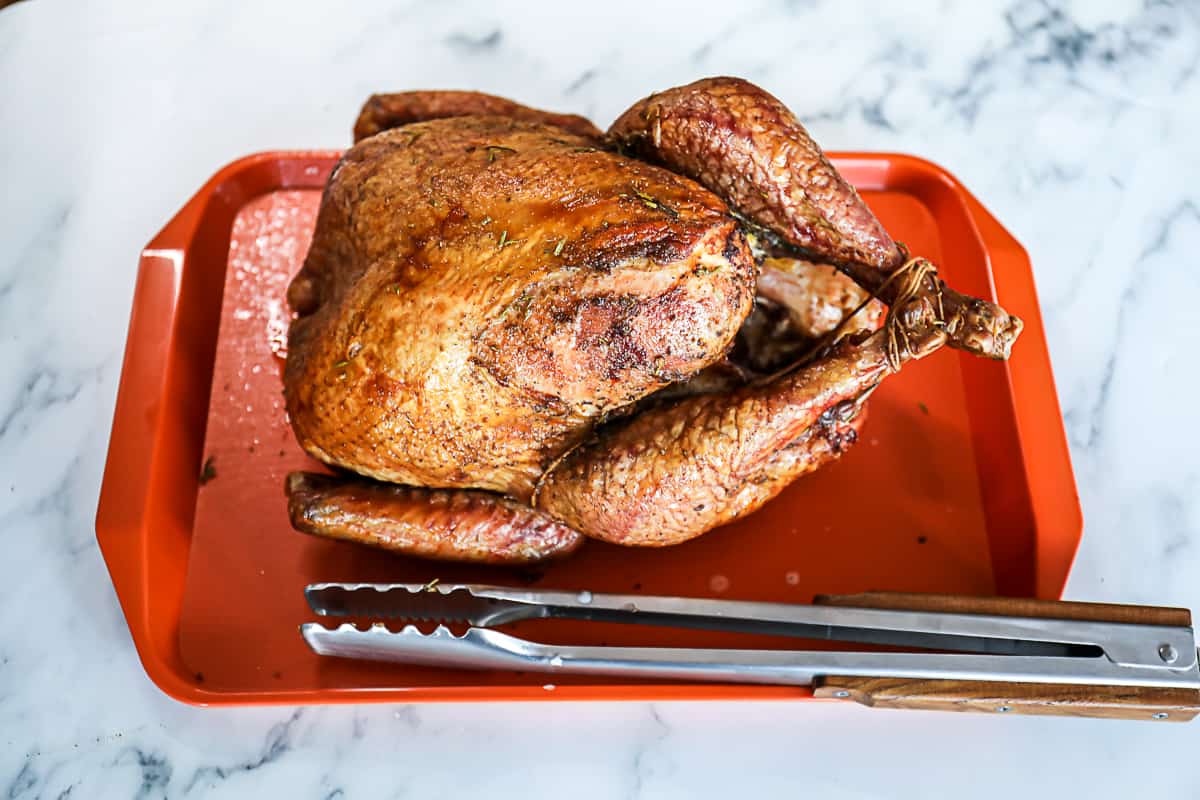 Smoked Turkey Recipe on Traeger Tray with Tongs