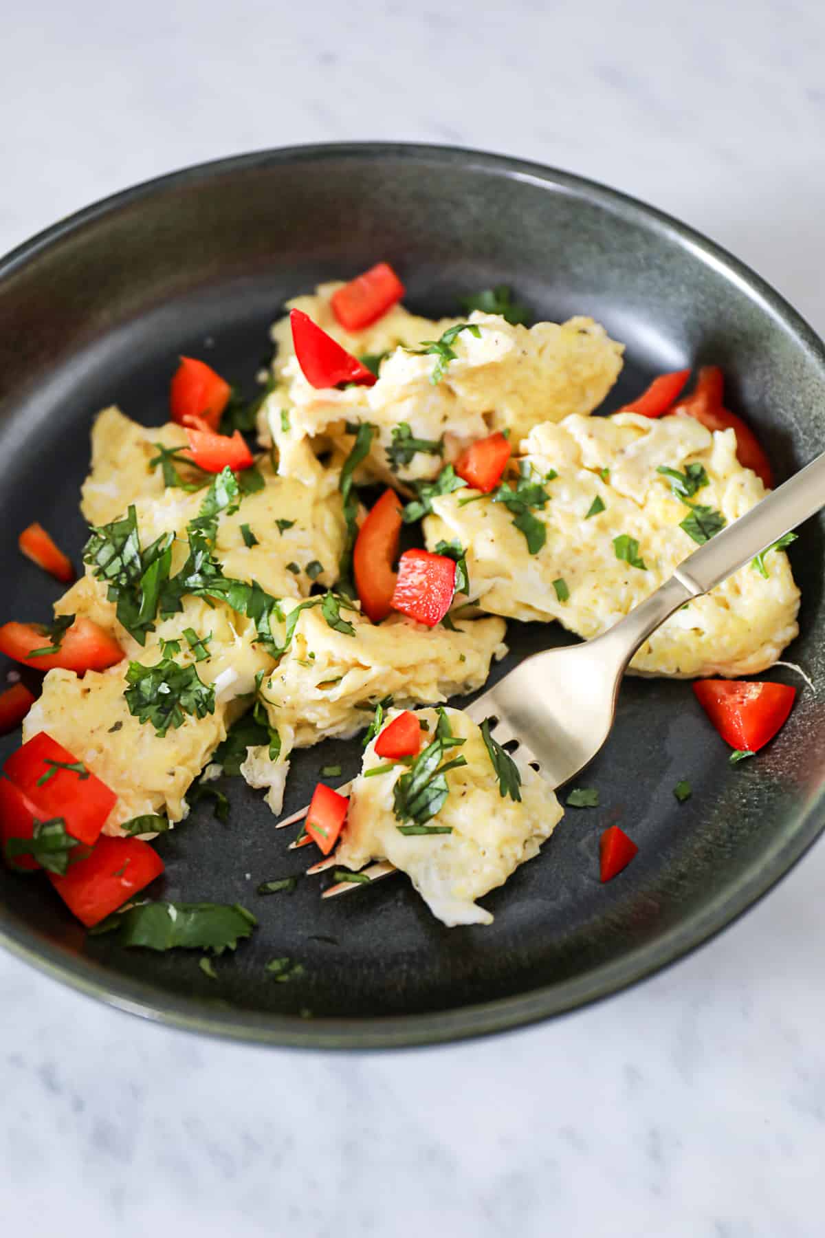 Soft Scrambled Eggs on a plate with cilantro and pepper