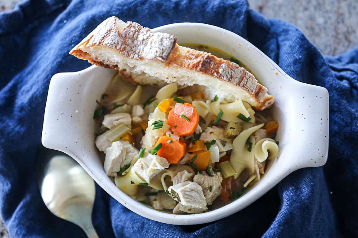 Bowl of Instant Pot Chicken Noodle Soup served with bread