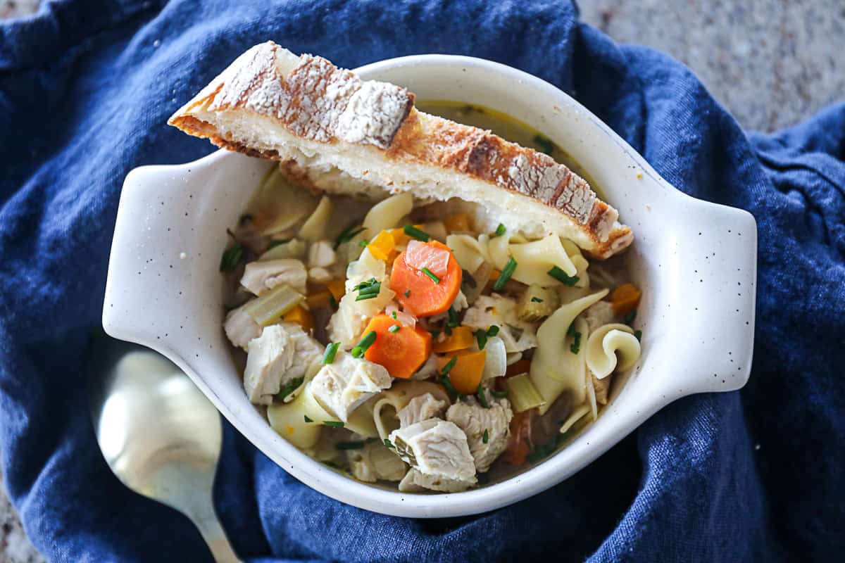 Instant Pot Creamy Chicken Noodle Soup with sourdough bread in a bowl