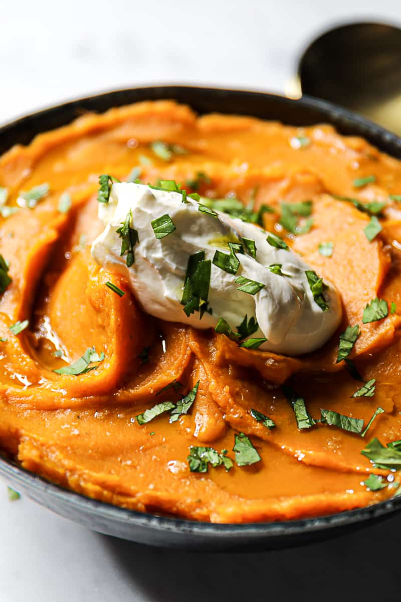Crock Pot sweet potatoes mashed with sour cream and herbs in a side dish bowl
