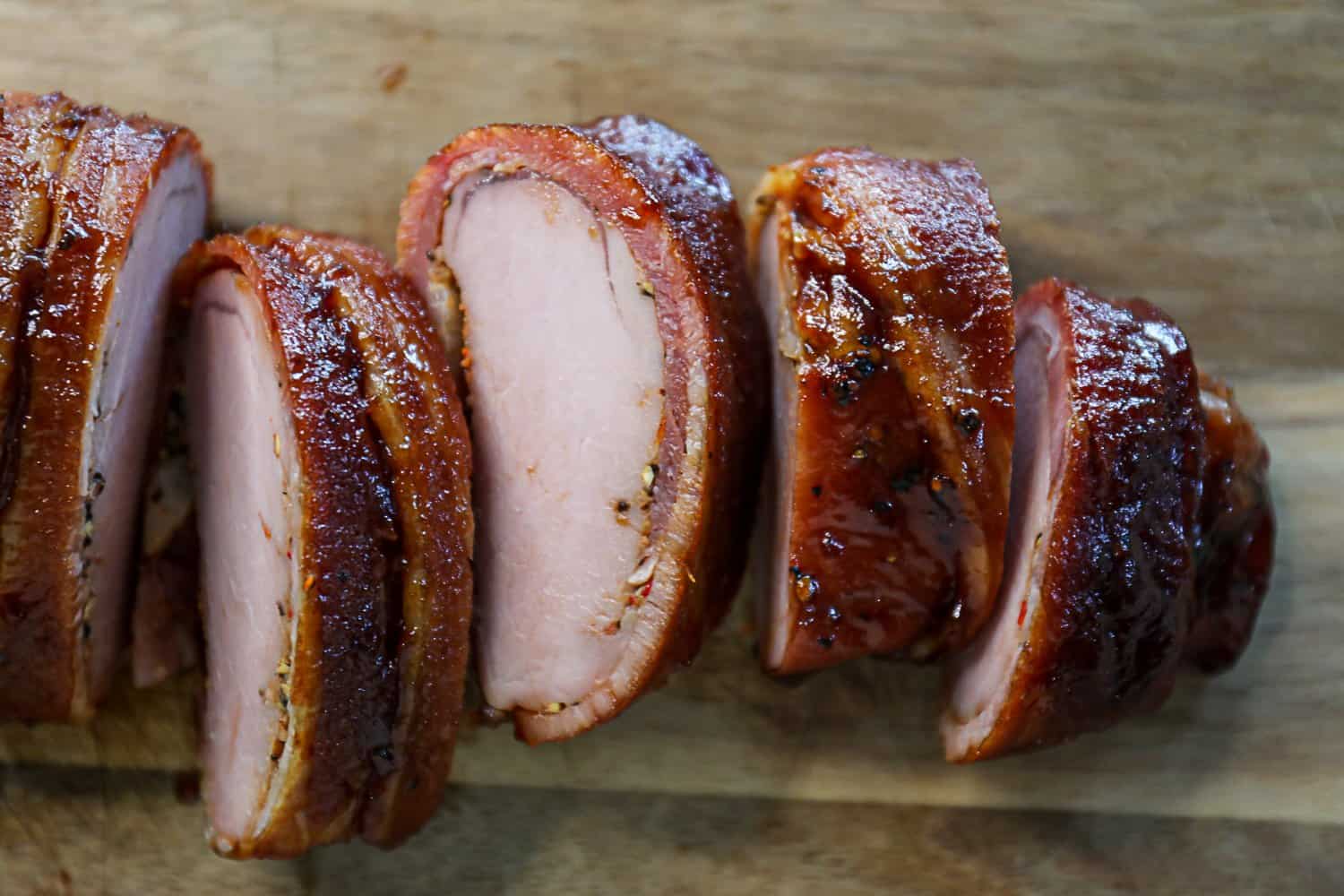 Sliced Smoked Bacon Wrapped Pork Tenderloin On A Cutting Board
