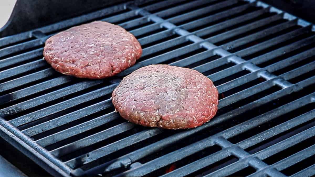 Cooking half pound burger patties on a gas grill