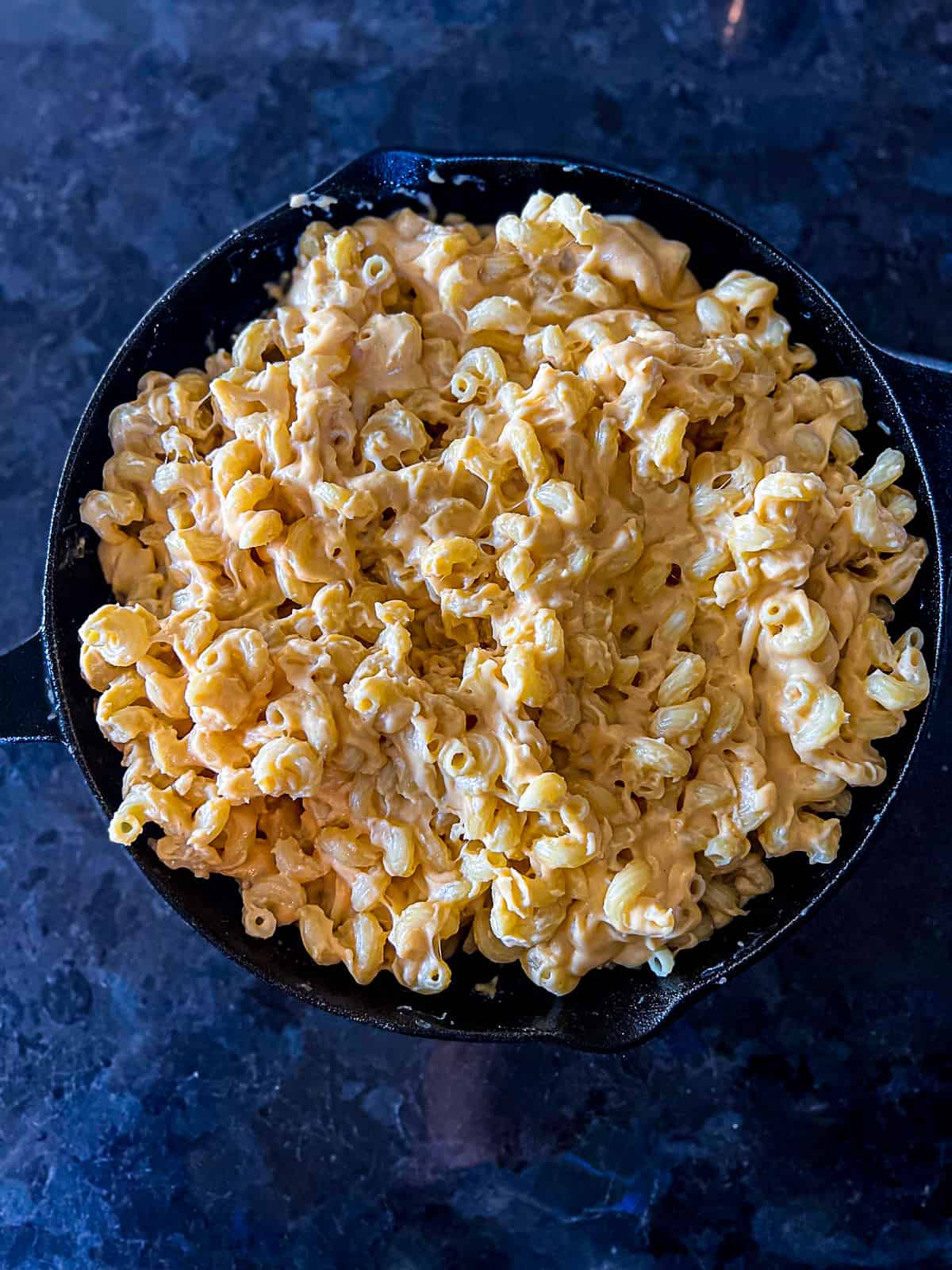 Creamy 3 cheese filling smoker mac and cheese in a cast iron skillet
