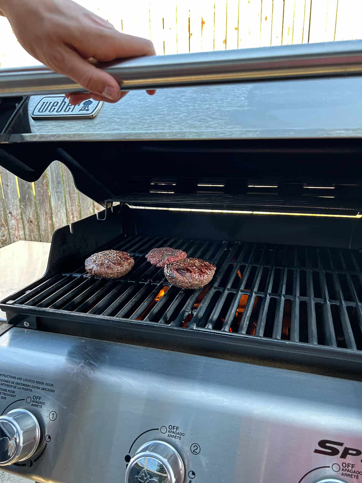 Grilling burgers on each side over direct heat on Weber gas grill Sip Bite Go