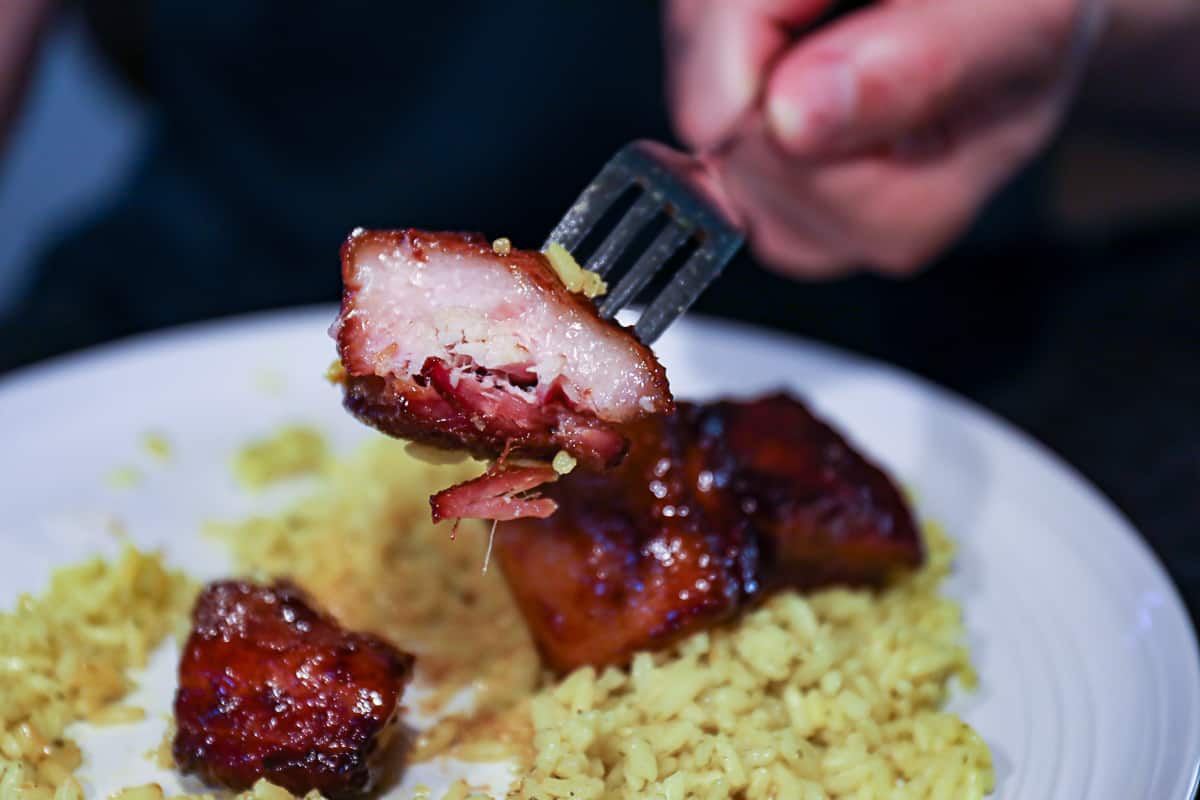 Showing what is pork belly with smoked burnt end style meat over rice dinner