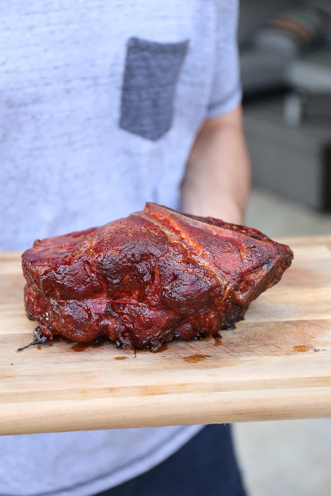 Smoked Food Blogger Holding Pellet Smoker Bone In Pork Shoulder