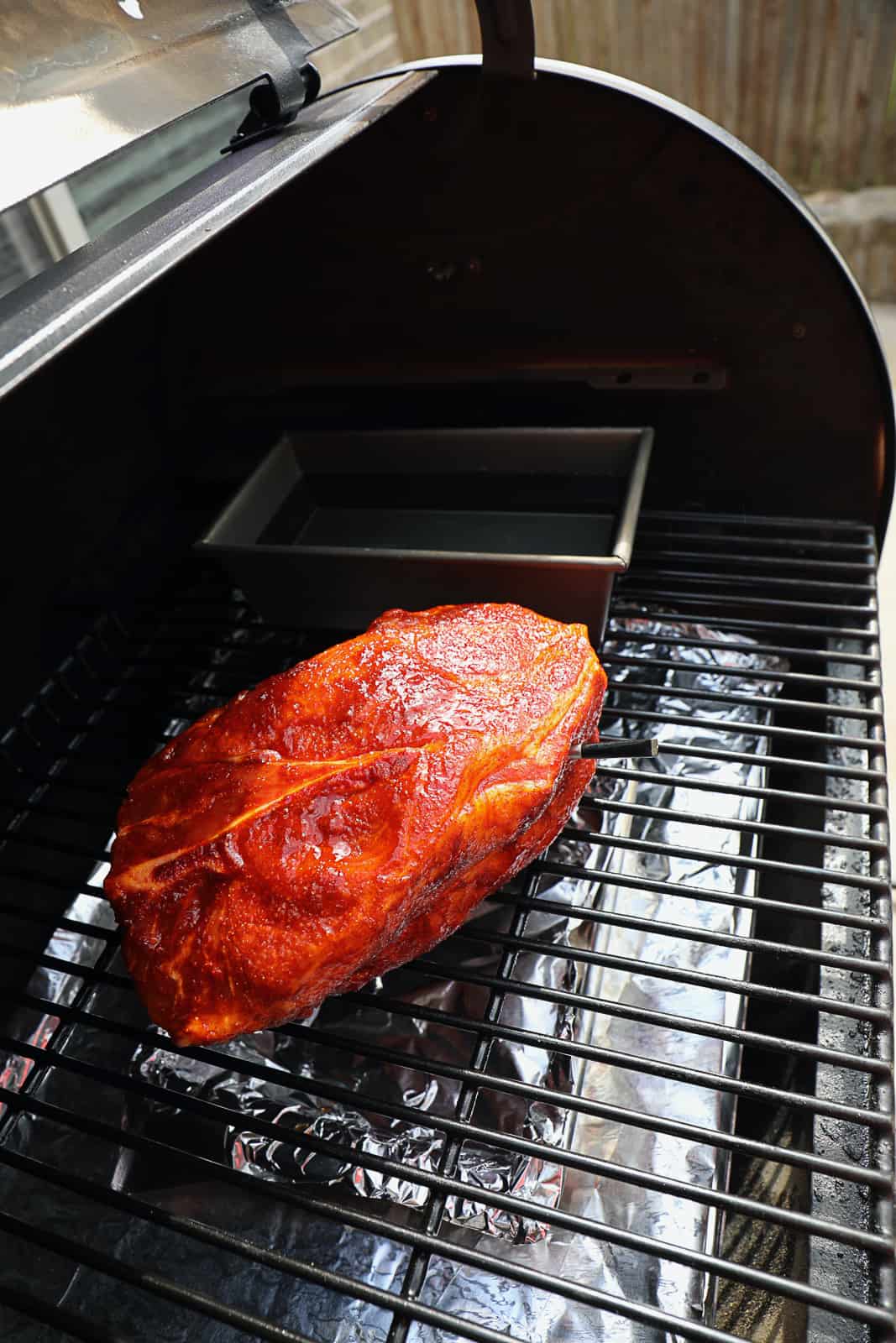 Smoking Bone In Pork Shoulder on Traeger Grills With water bowl to the side