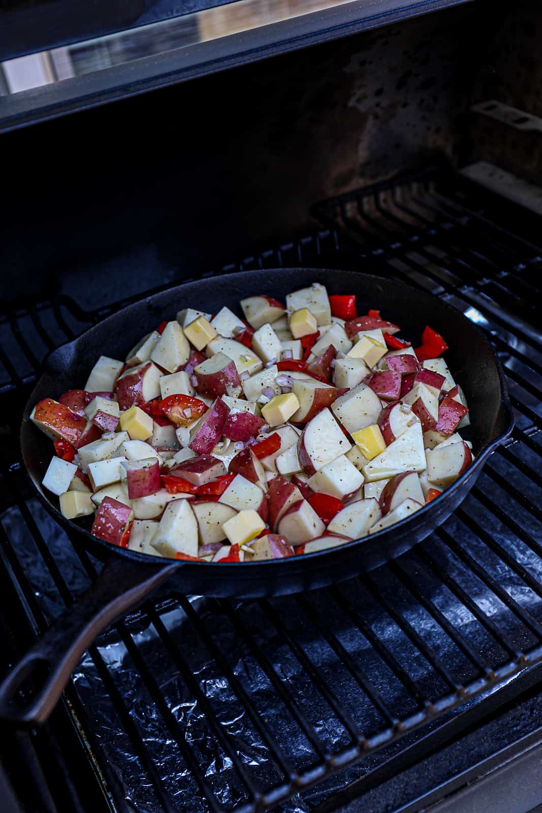Cast iron skillet on the Traeger pellet grills with red potato ingredients