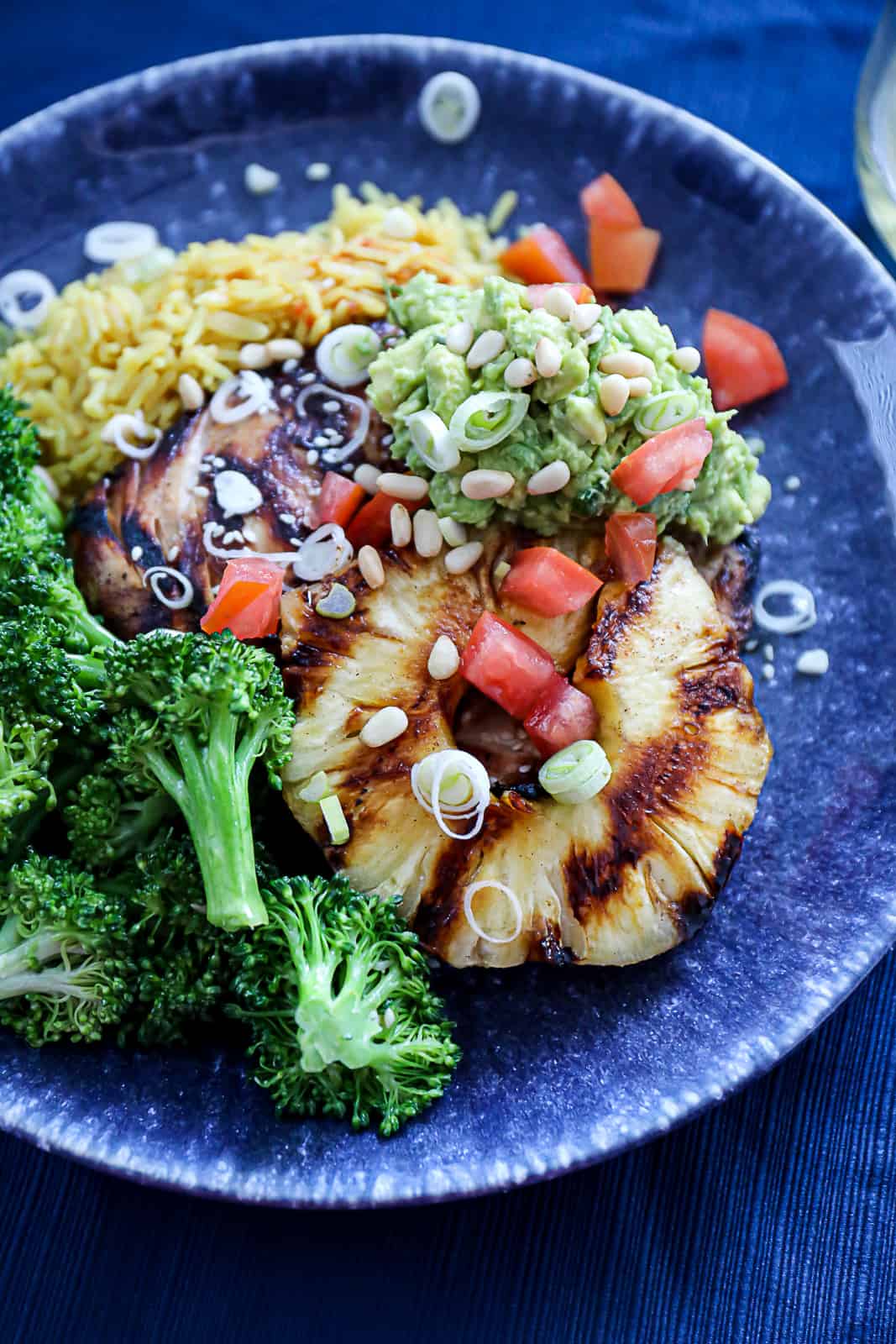 Grilled Pineapple with grilled chicken rice broccoli and salsa on a dinner plate