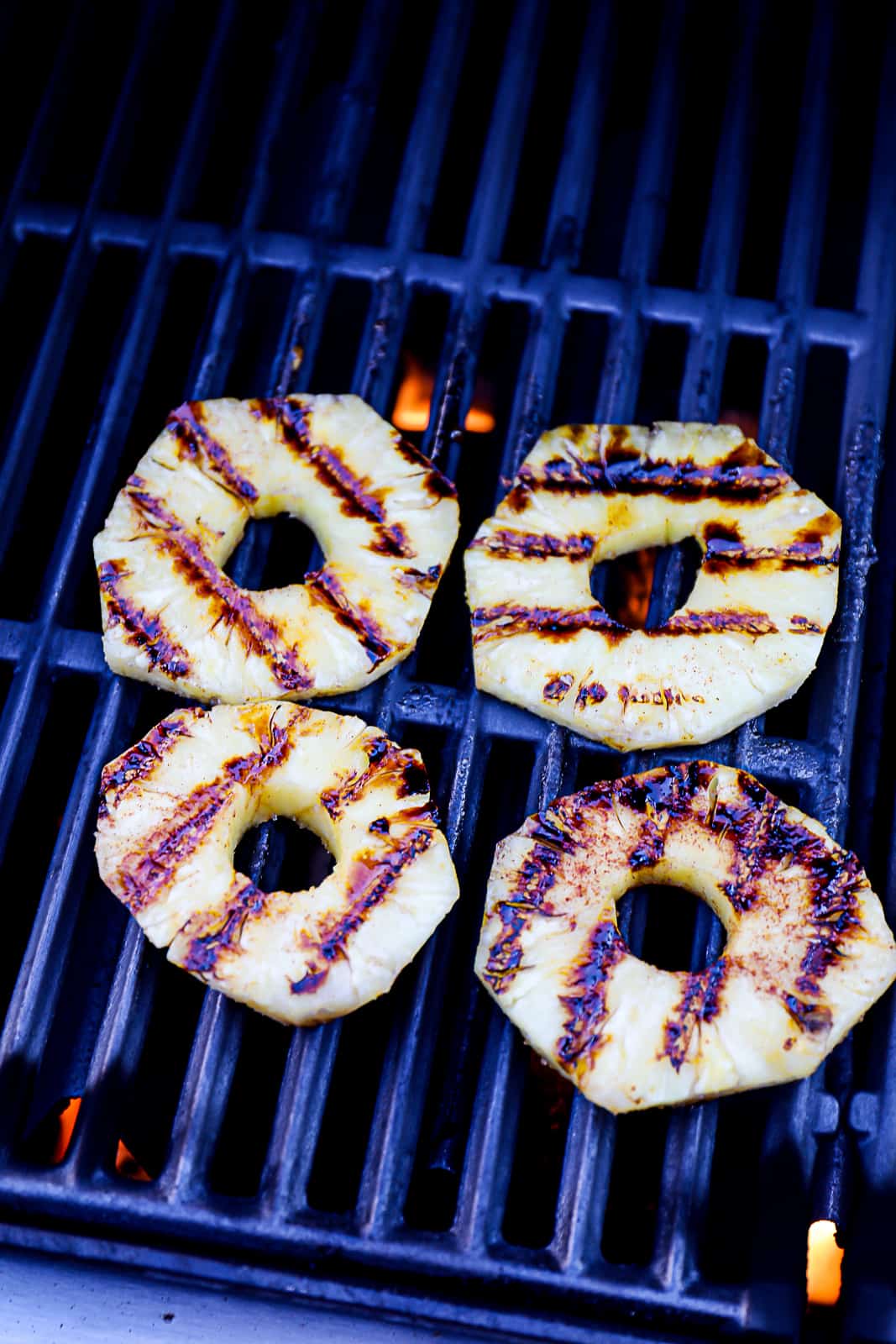 Grilling pineapple slices on a gas grill on high heat