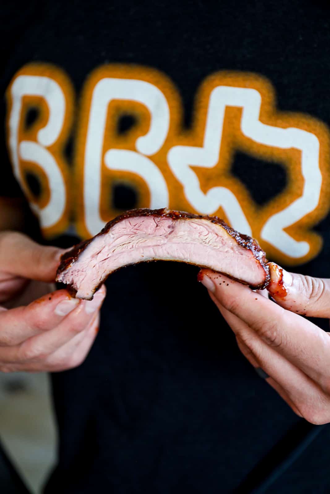 Holding Smoked 321 ribs with BBQ sauce