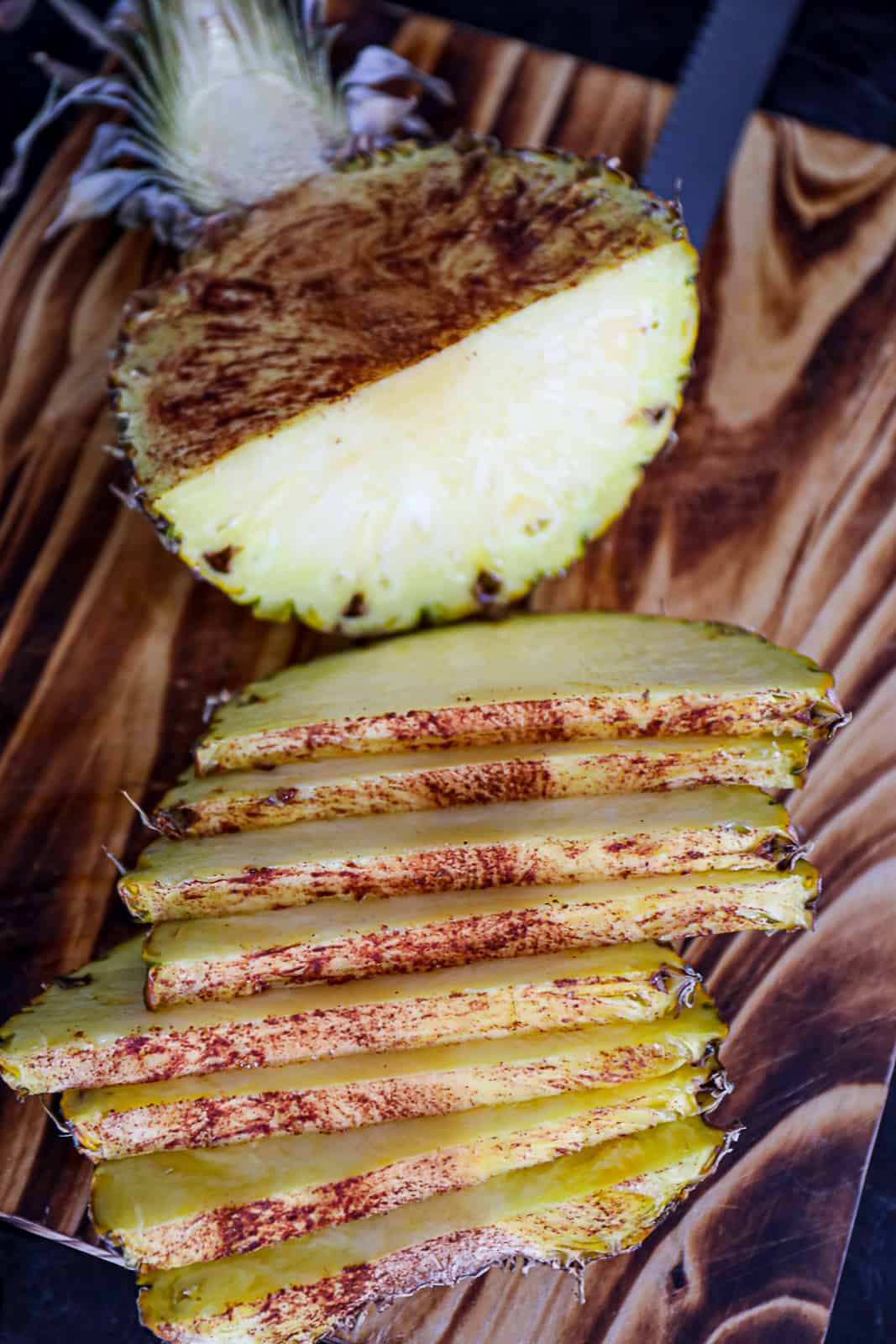 Sliced Smoked Pineapple with cinnamon on a cutting board